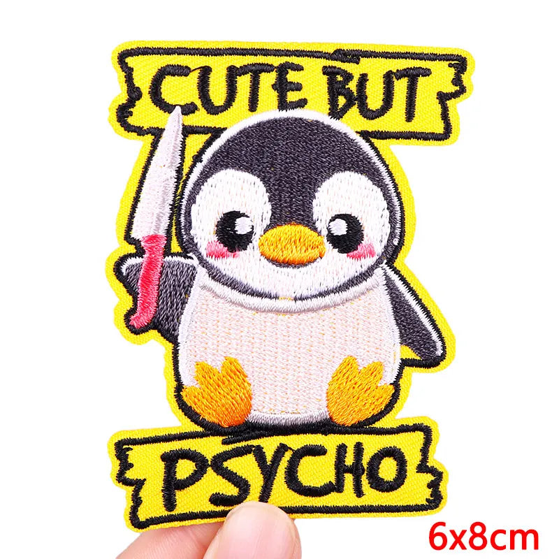 Embroidered patch of a penguin with a knife and text 'Cute But Psycho' on a yellow background.