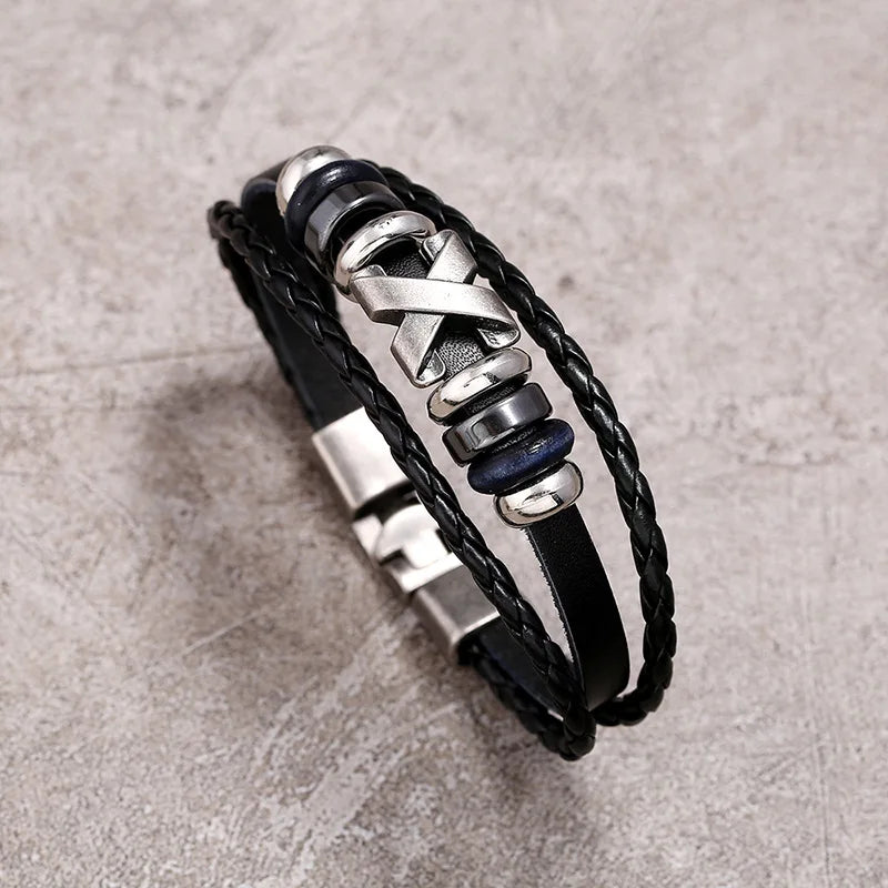 Black leather bracelet with metal elements on a textured gray background