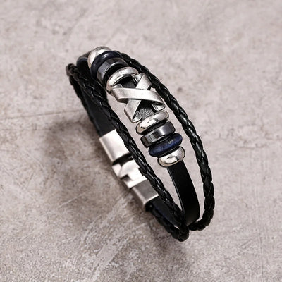 Black leather bracelet with metal elements on a textured gray background