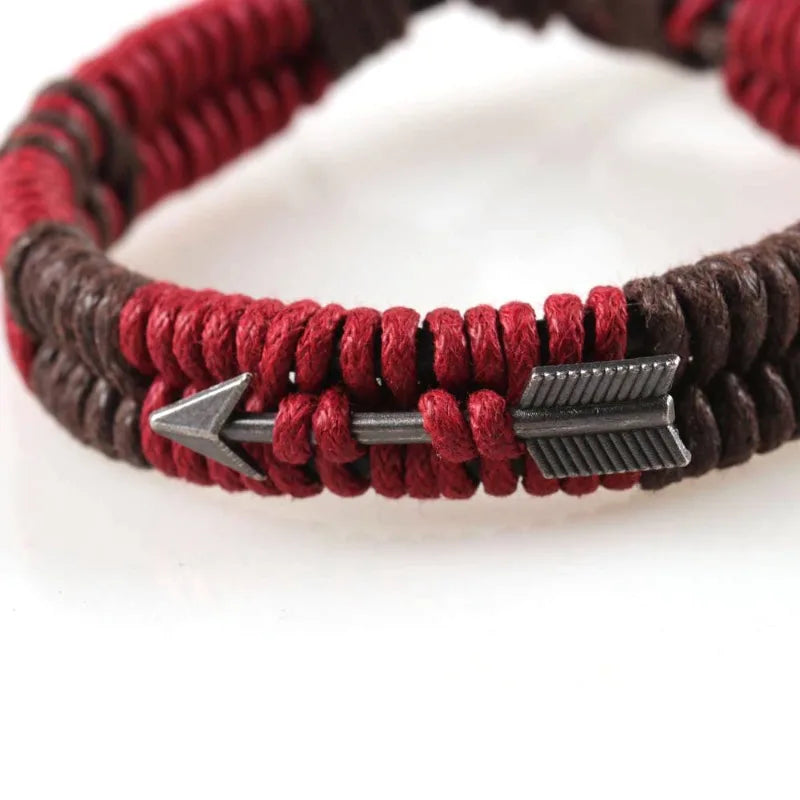 Bracelet with red and brown cord and silver arrow-shaped clasps on a white background