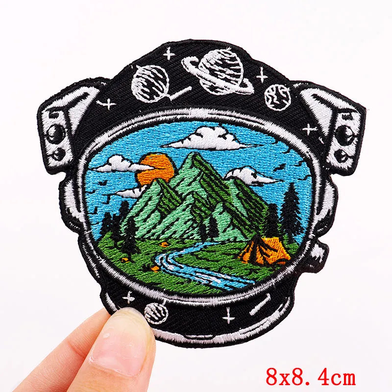 Embroidered patch with mountain and camping scene held by a hand, with '8x8.4cm' text at the bottom.