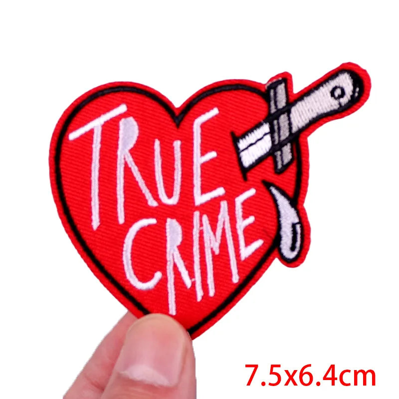 Heart-shaped patch with 'True Crime' text and a knife on a white background