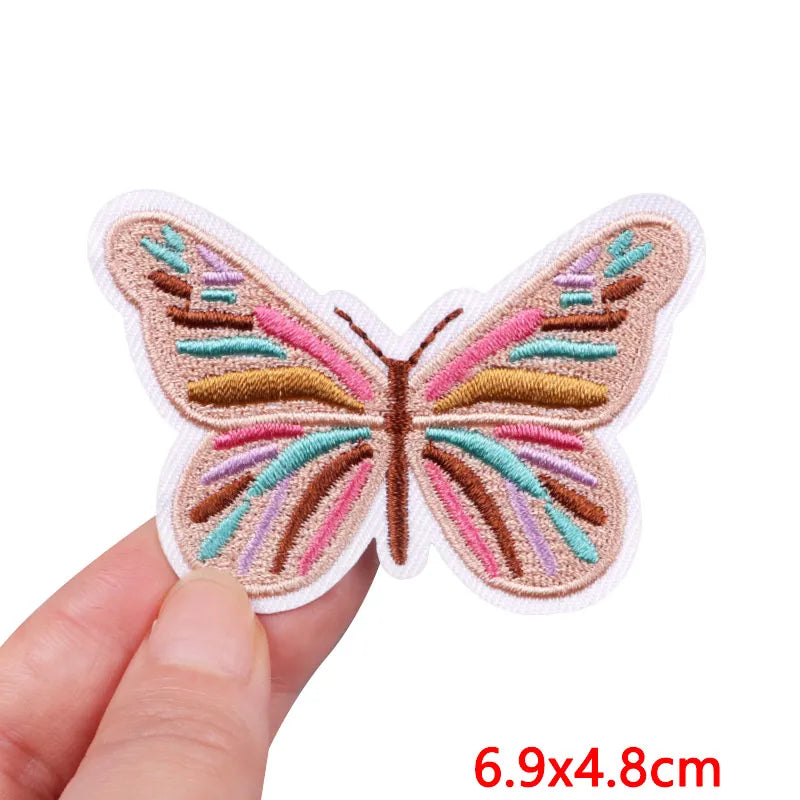 Butterfly-shaped patch held by a hand with dimensions displayed