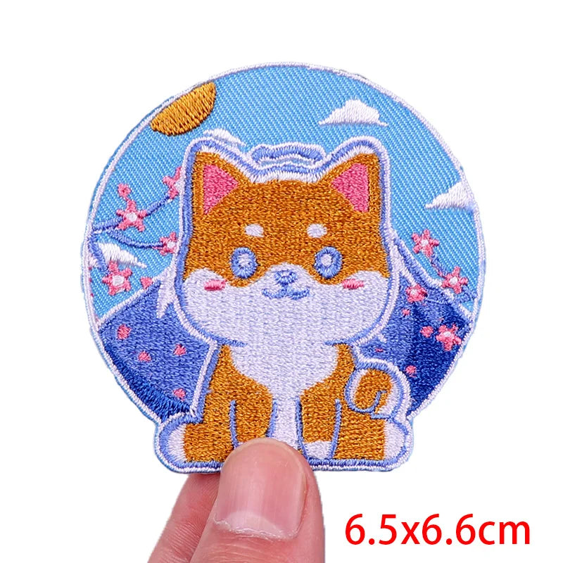 Embroidered patch of a cartoon fox on a blue background held by a finger.