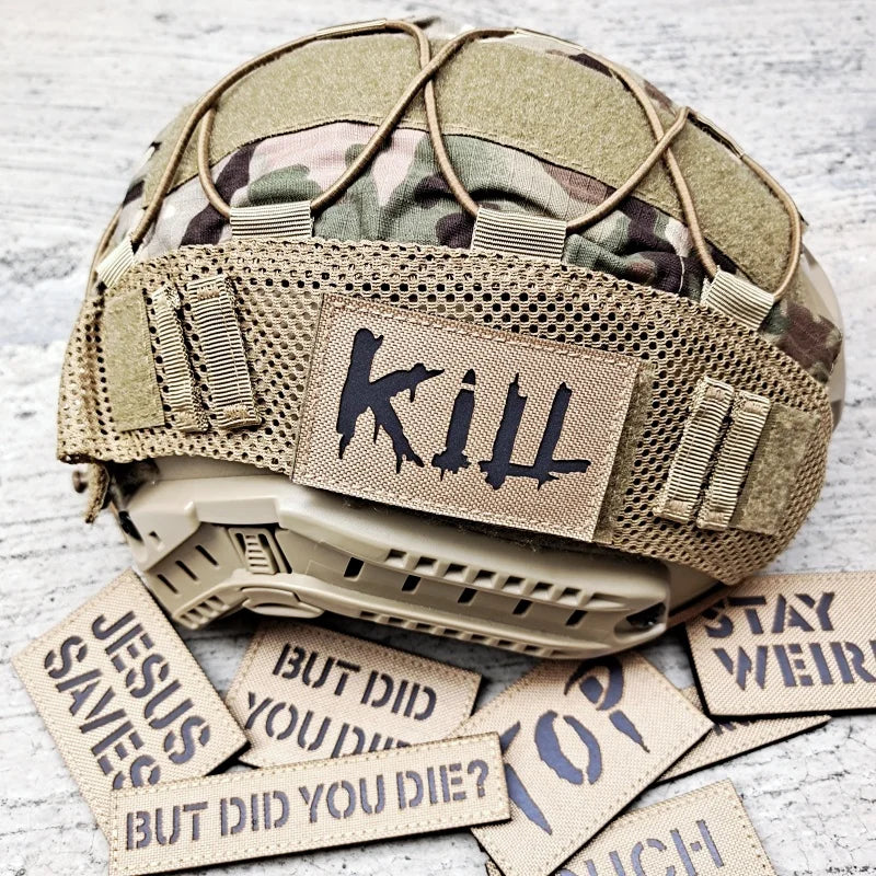 Tactical helmet with 'Kill' patch and motivational stickers on a textured surface