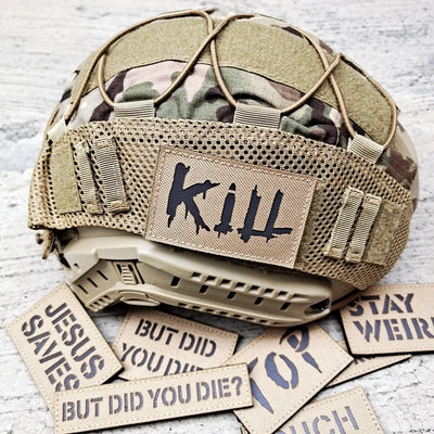 Tactical helmet with 'Kill' patch and motivational stickers on a textured surface