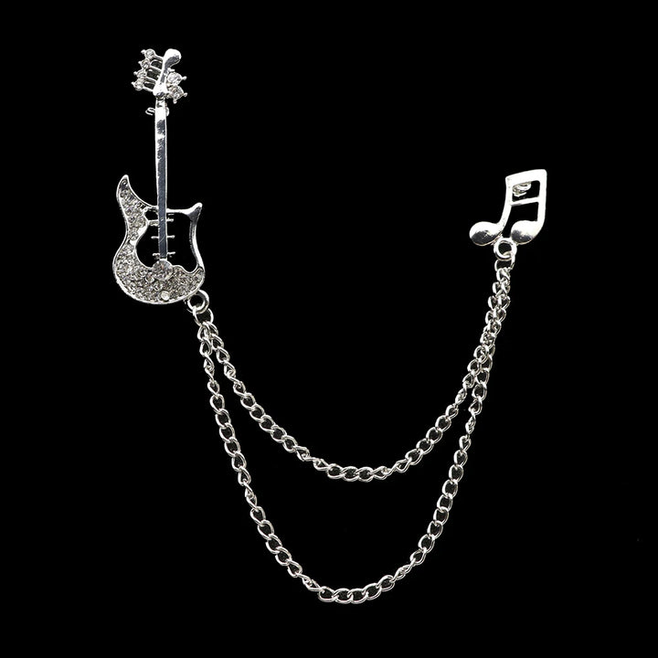 Silver brooch with guitar and music note design on a black background