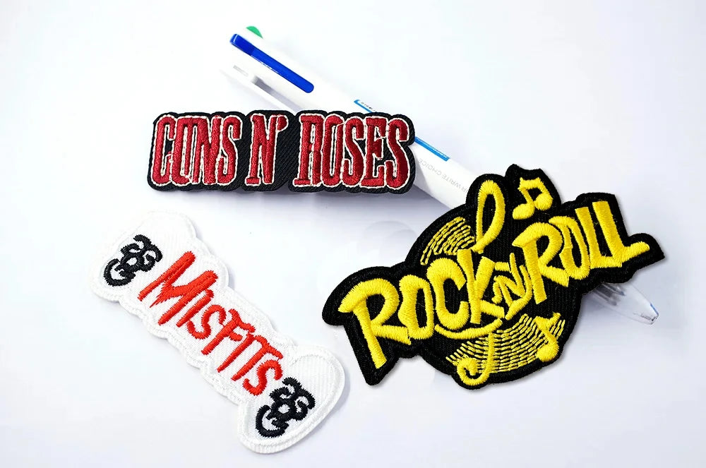 Three patches with 'Guns N' Roses', 'Misfits', and 'Rock n Roll' designs on a white background.