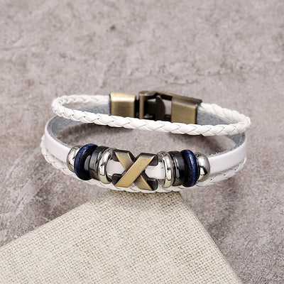 White braided leather bracelet with metal beads on a textured surface