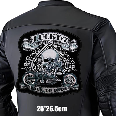 Black leather jacket with a large embroidered patch on the back featuring a skull and motorcycle design.