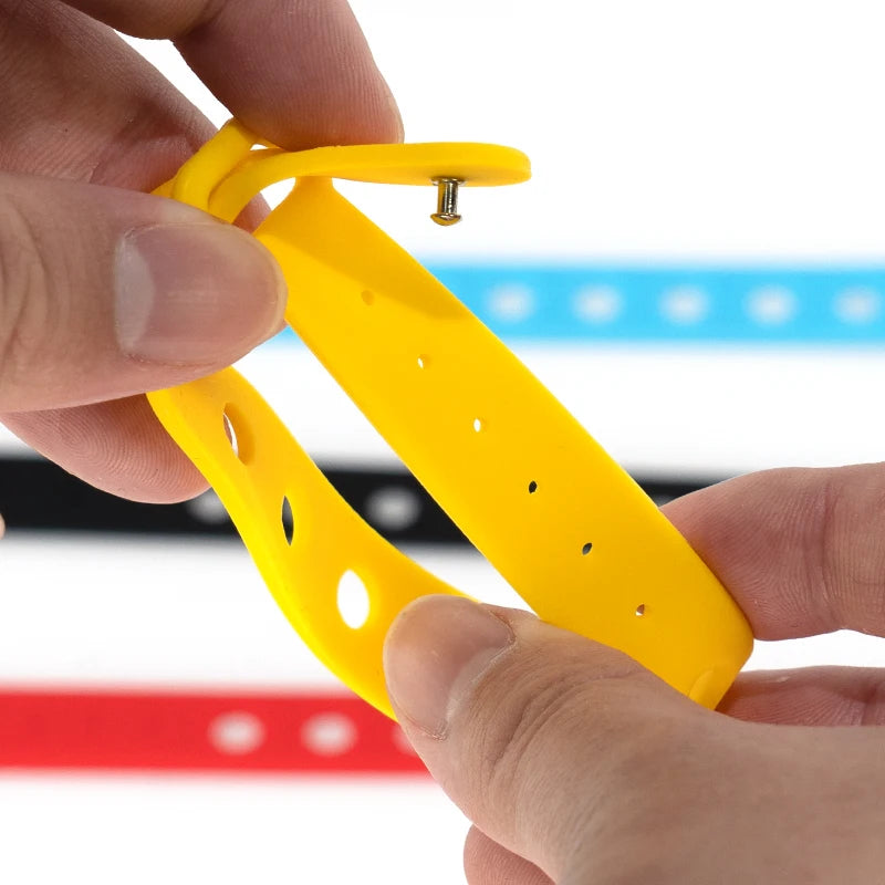 Yellow wrist band held by hands with a colorful background