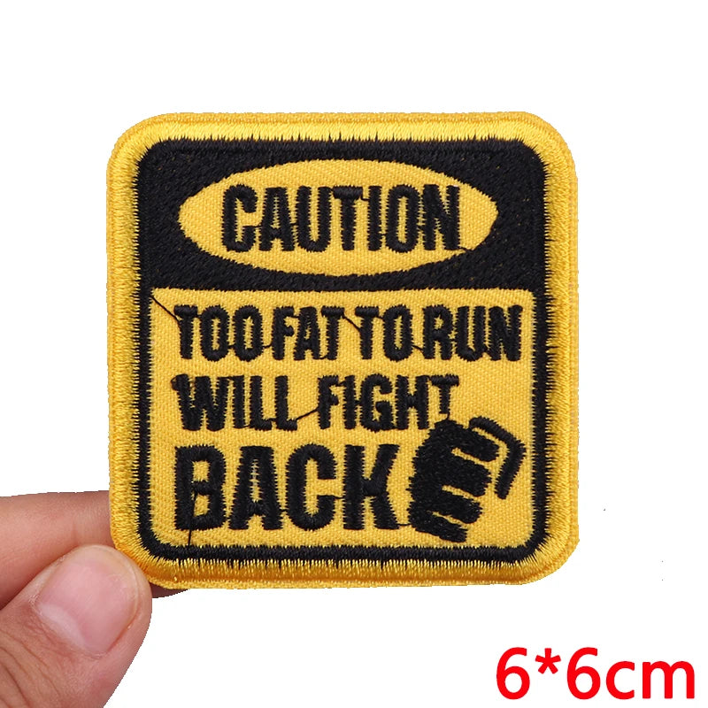Embroidered patch with 'Caution: Too Fat to Run, Will Fight Back' text on a yellow background.
