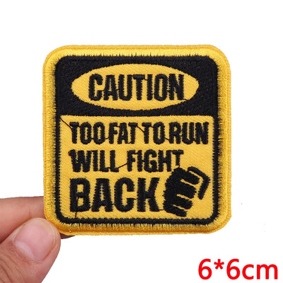 Embroidered patch with 'Caution: Too Fat to Run, Will Fight Back' text on a yellow background.