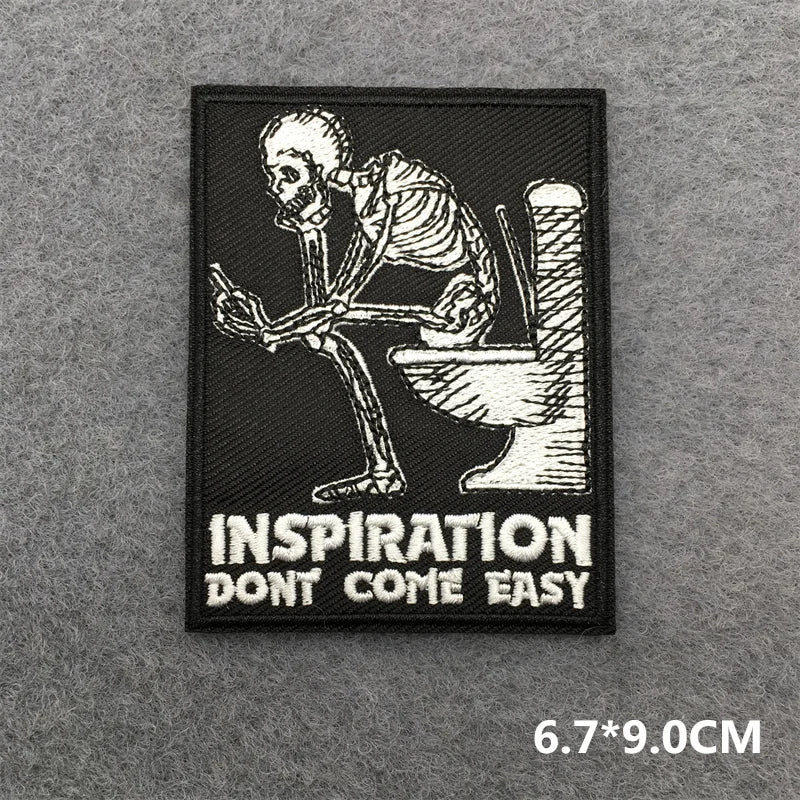 Patch with skeleton on toilet and 'Inspiration Don't Come Easy' text on a gray background