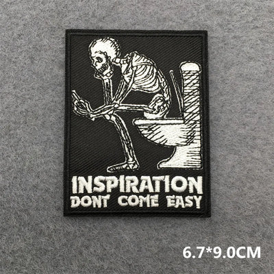 Patch with skeleton on toilet and 'Inspiration Don't Come Easy' text on a gray background