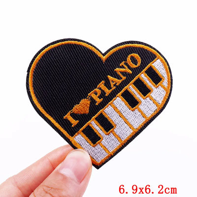Heart-shaped patch with piano design held by a hand on a white background