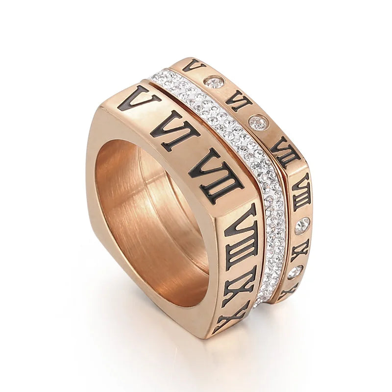 Rose gold ring with Roman numeral design on a white background