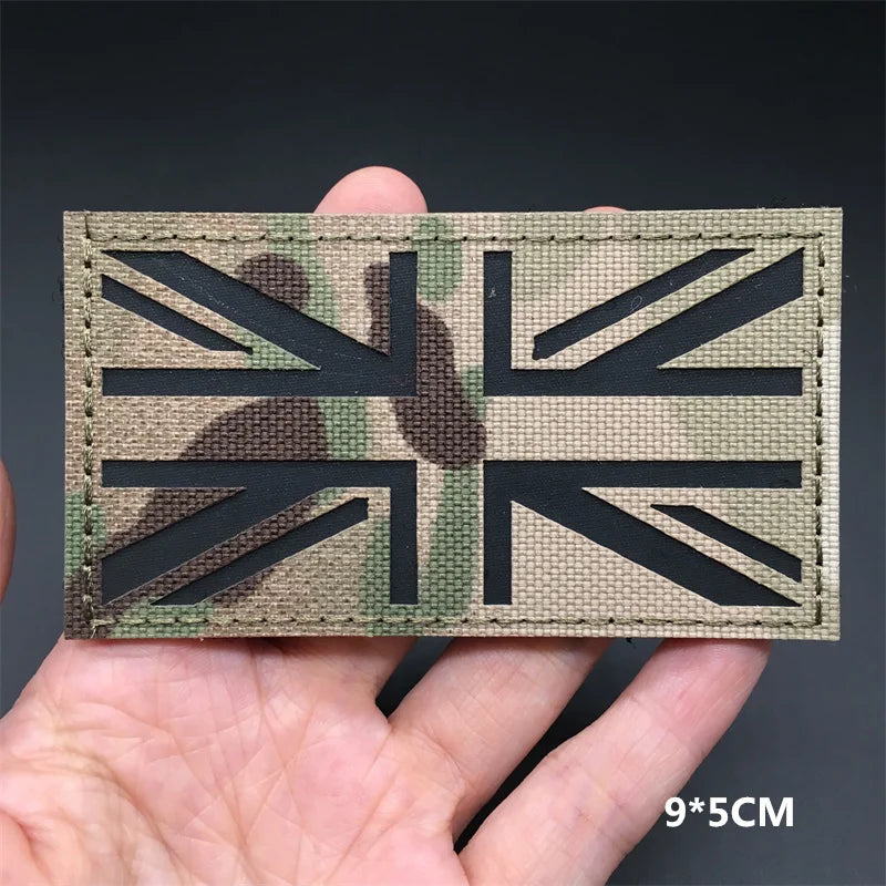 Multicam British flag patch held in a hand with a dark background