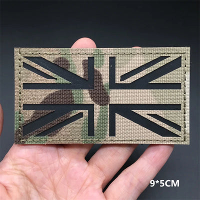 Multicam British flag patch held in a hand with a dark background