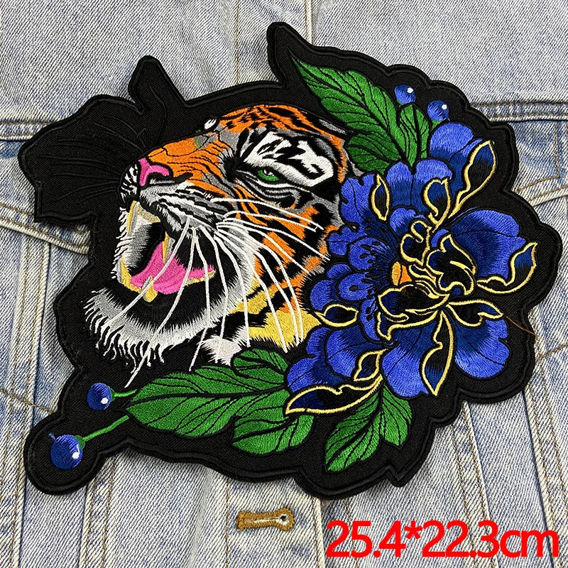Embroidered patch with a tiger and floral design on denim fabric.