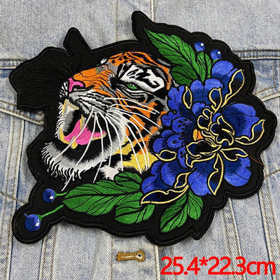 Embroidered patch with a tiger and floral design on denim fabric.