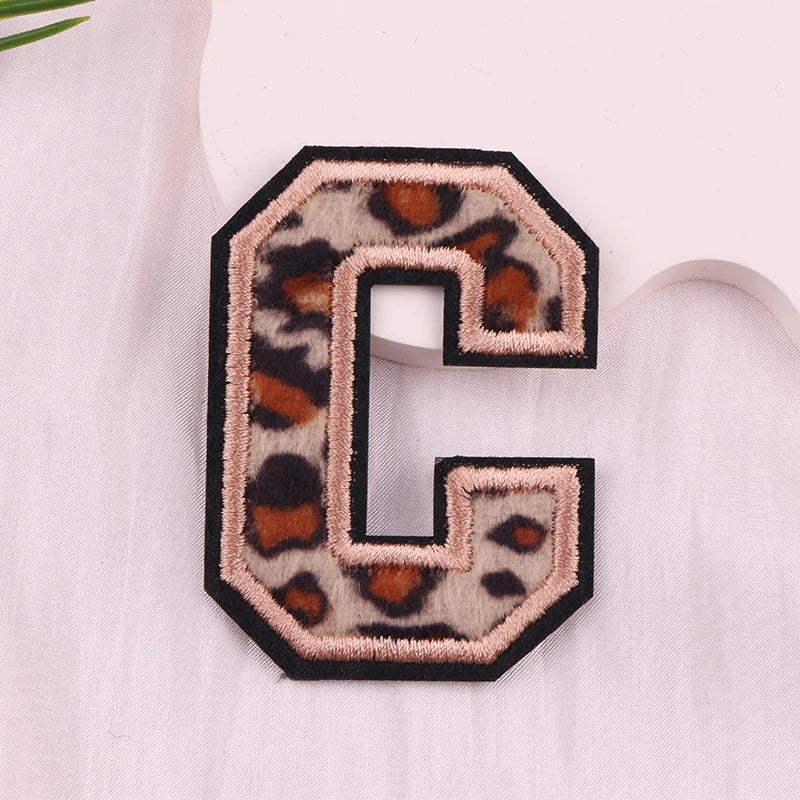 Leopard print letter 'C' patch on a light fabric background