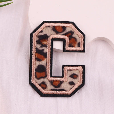 Leopard print letter 'C' patch on a light fabric background