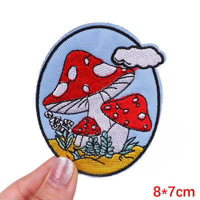 Mushroom-themed patch held by a hand with a white background