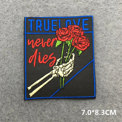 Patch with skeleton hand holding roses and 'True Love never dies' text on a gray background