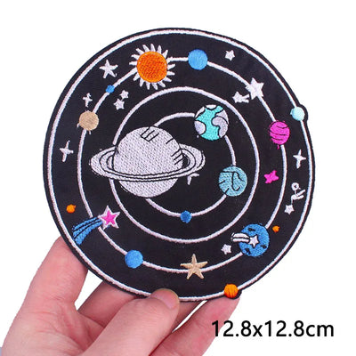 Circular patch with solar system design held by a hand, size 12.8x12.8cm.