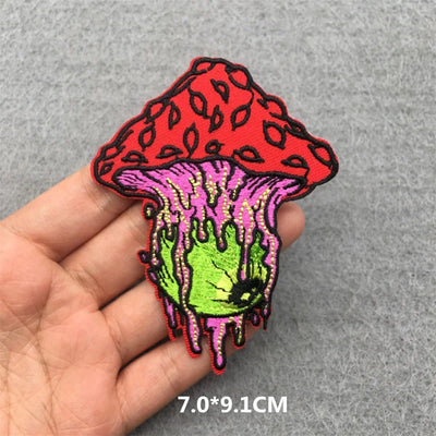 Colorful mushroom-shaped patch held by a hand on a gray background