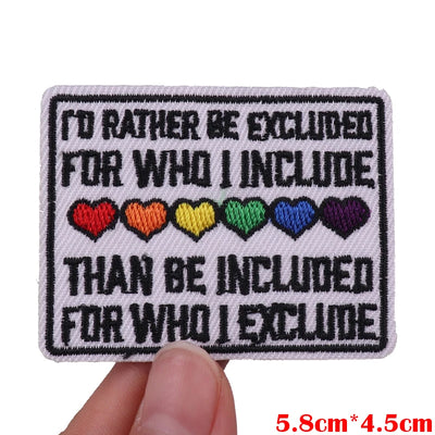 Embroidered patch with text and colorful hearts held by a hand on a white background