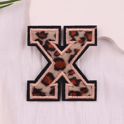 Leopard print letter 'X' patch on a white background