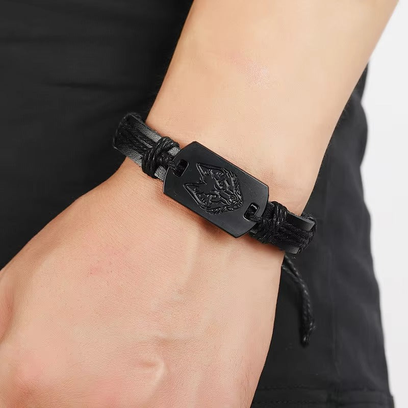 Black leather bracelet with a tiger emblem on a wrist against a neutral background