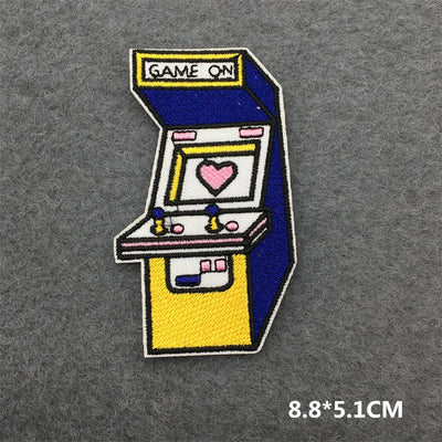 Embroidered patch of an arcade machine with a heart on a gray background