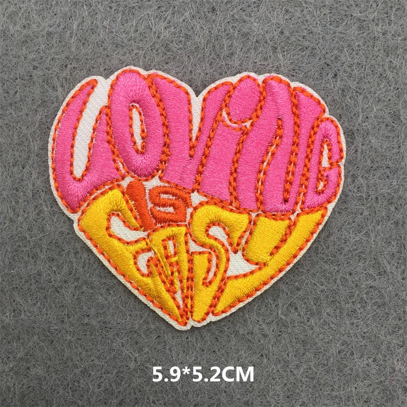 Heart-shaped patch with 'LOVING IS EASY' text on a gray background
