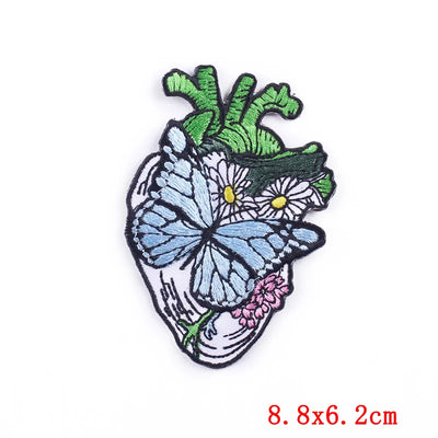 Heart-shaped patch with butterfly and floral design on a white background