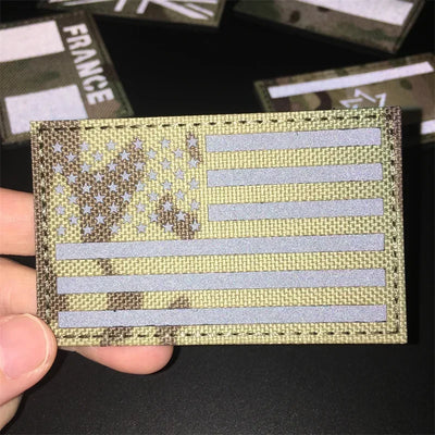 American flag patch held by a hand with blurred background