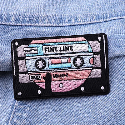 Embroidered patch of a cassette tape on a denim background