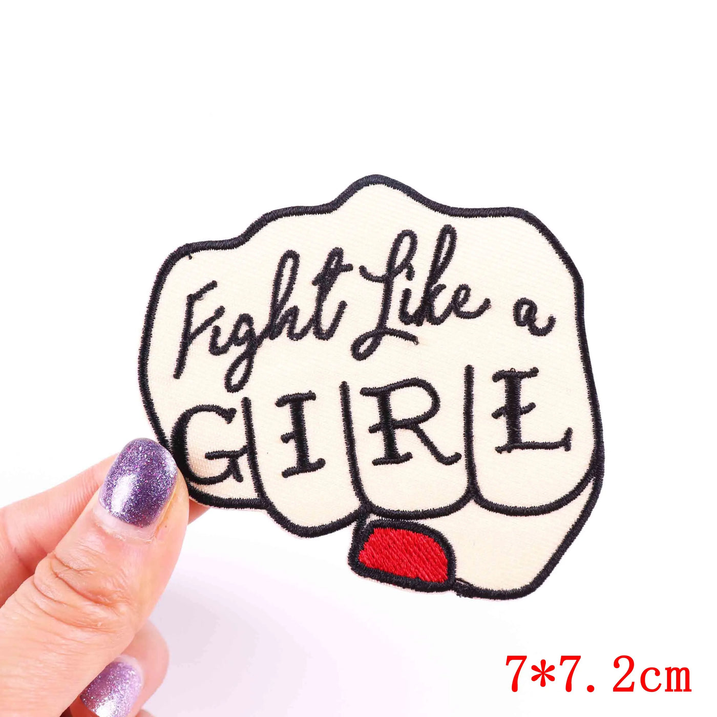 Patch with 'Fight Like a Girl' text held by a hand on a white background