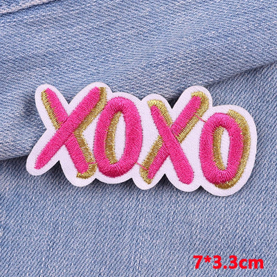 Embroidered patch with 'xoxo' text on denim fabric