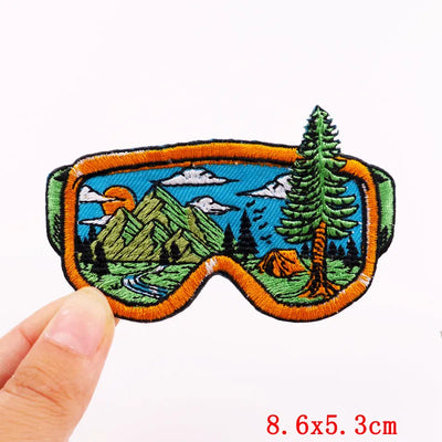 Embroidered patch with nature design held by a hand, on a white background