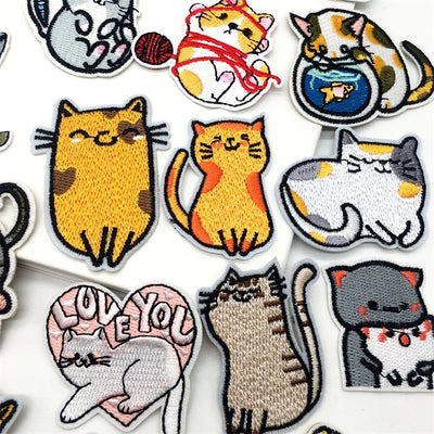Collection of various cat-themed patches on a white background