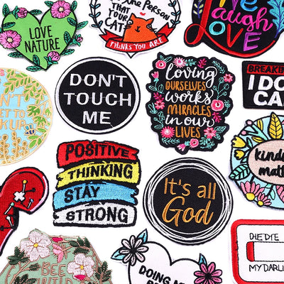 Collection of colorful patches with various messages and designs on a white background