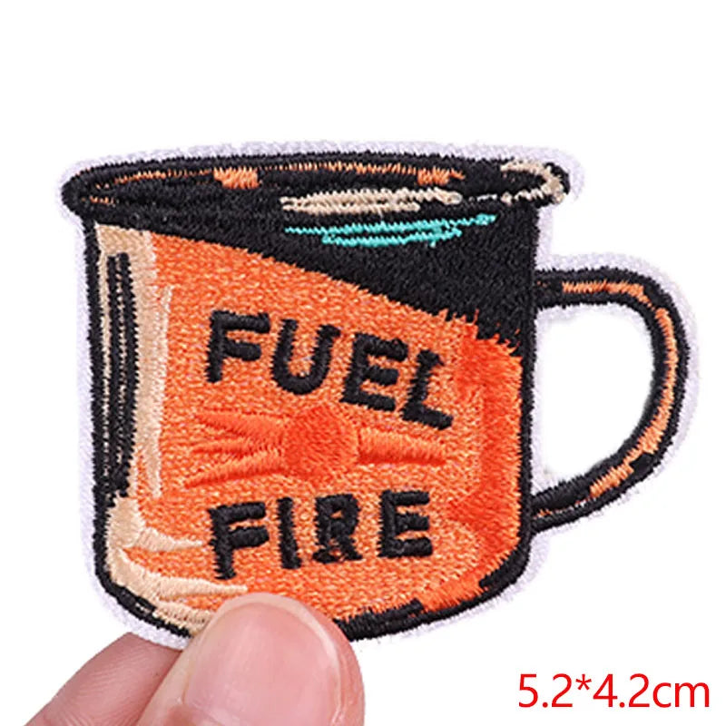 Embroidered patch of a mug labeled 'Fuel Fire' held by a hand with dimensions displayed.