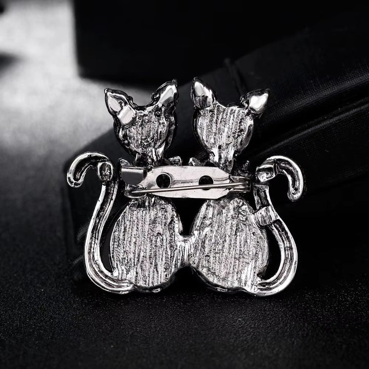 back side cat-like figures on a dark background showing safety pin 