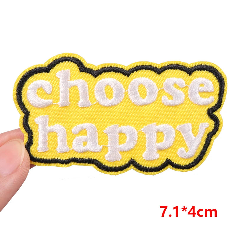 Yellow patch with 'choose happy' text held by a hand on a white background