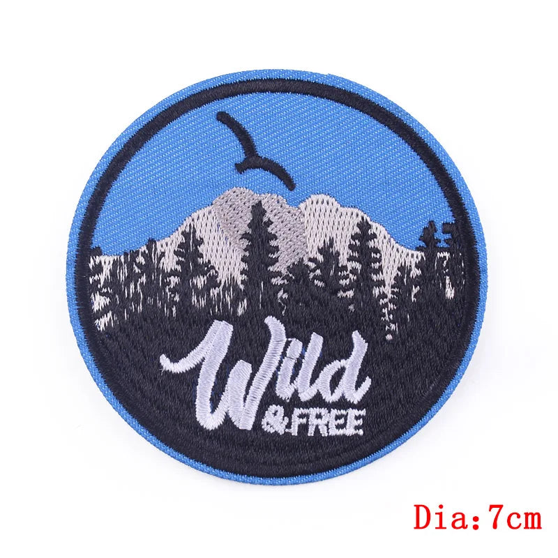 Round patch with mountain design and 'Wild & Free' text on a blue background