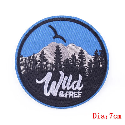 Round patch with mountain design and 'Wild & Free' text on a blue background
