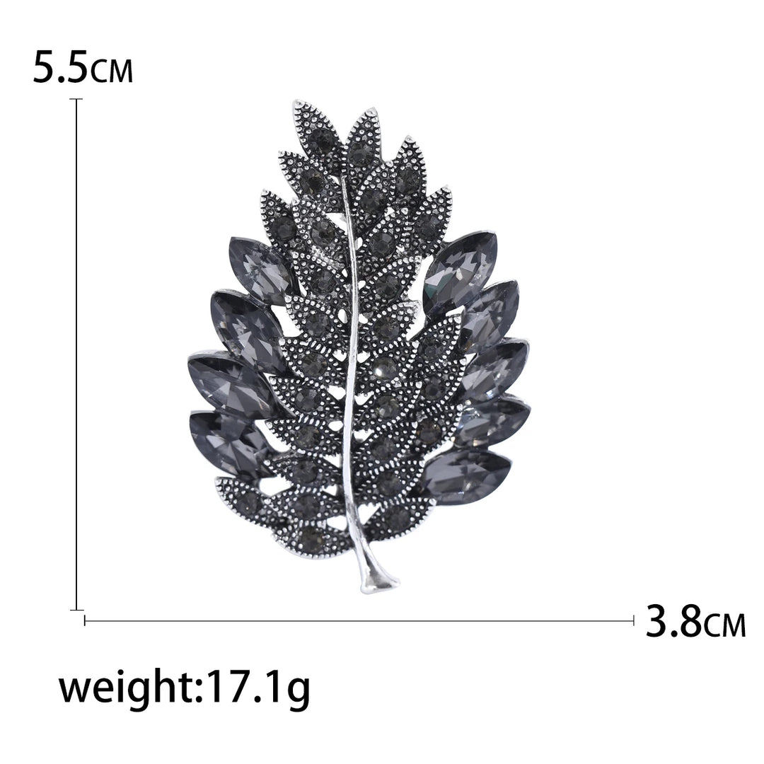 Leaf-shaped brooch with measurements and weight on a white background